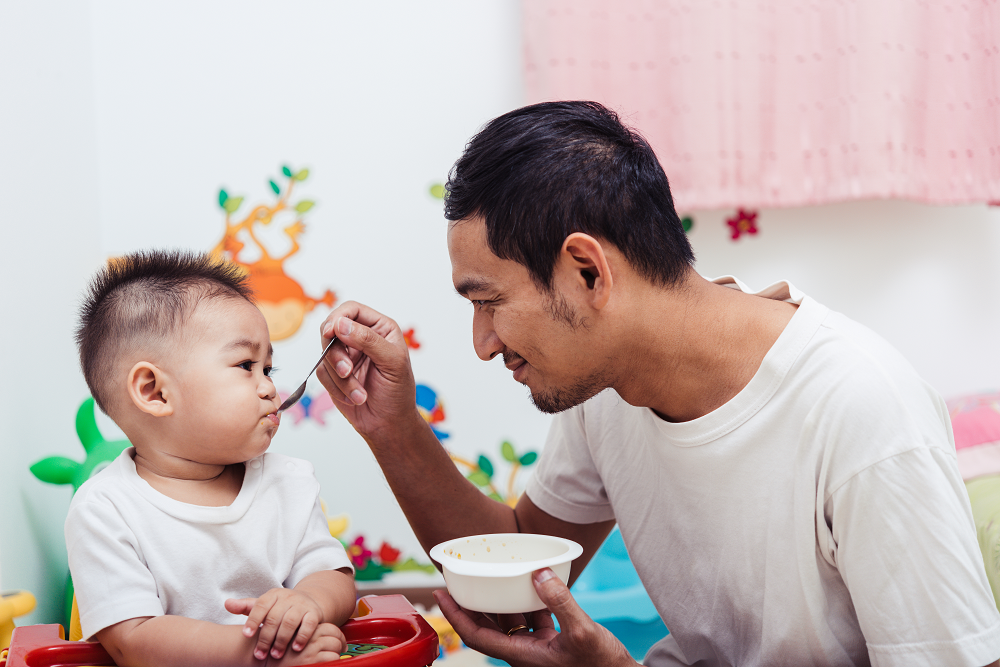 Father feeding baby son