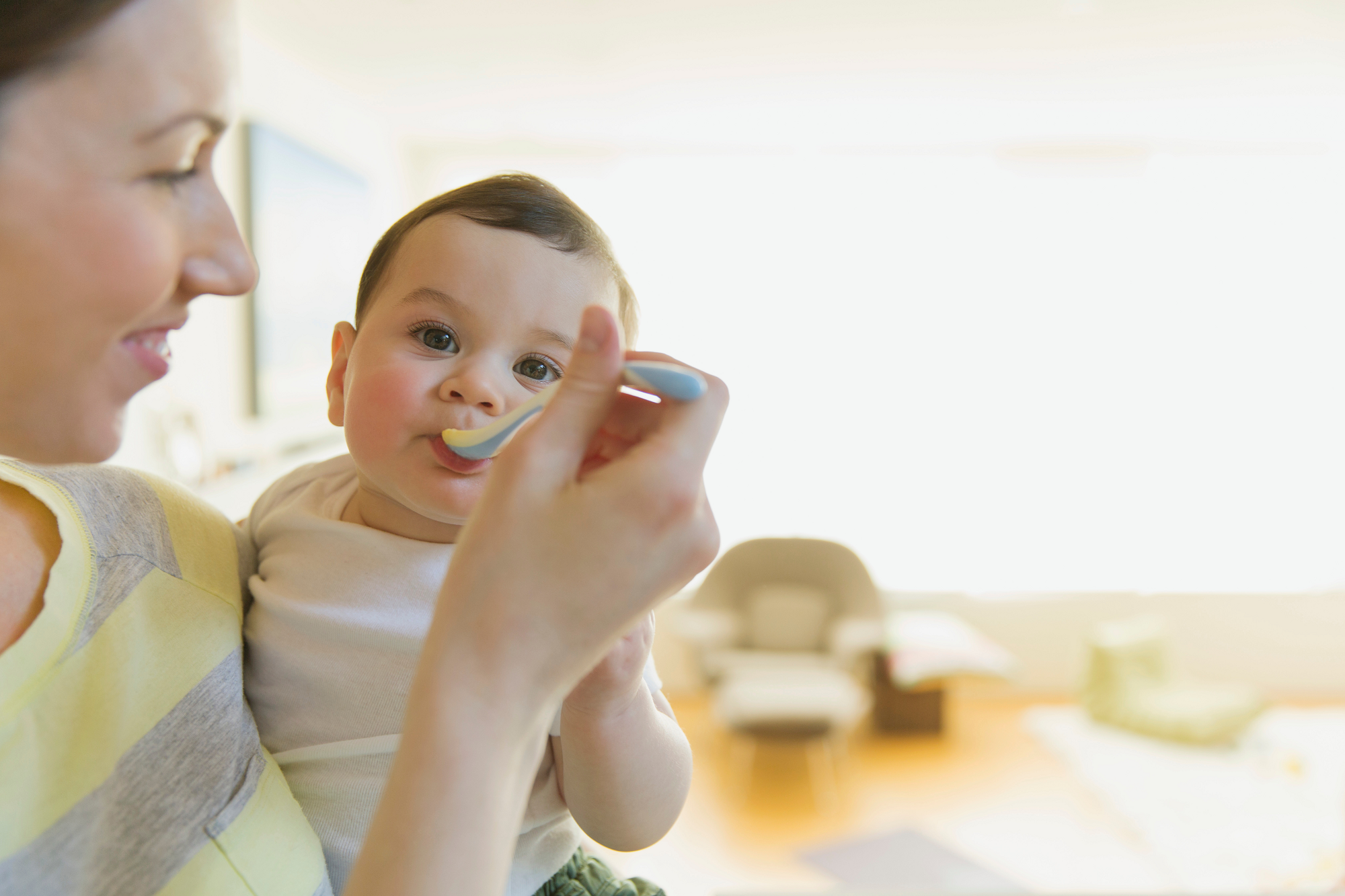 Mom spoon feeding baby