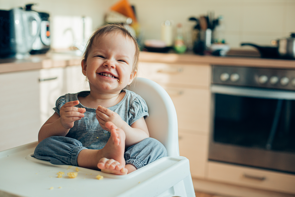 Baby smiling during mealtime in high chair
