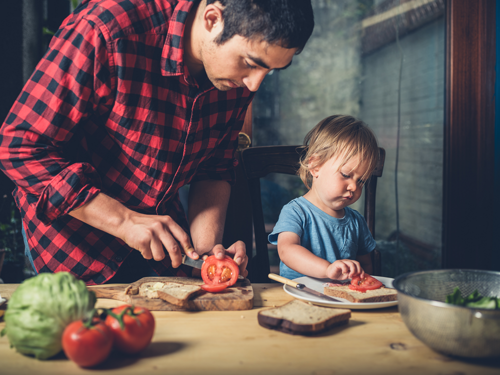 Father and toddler son cooking together