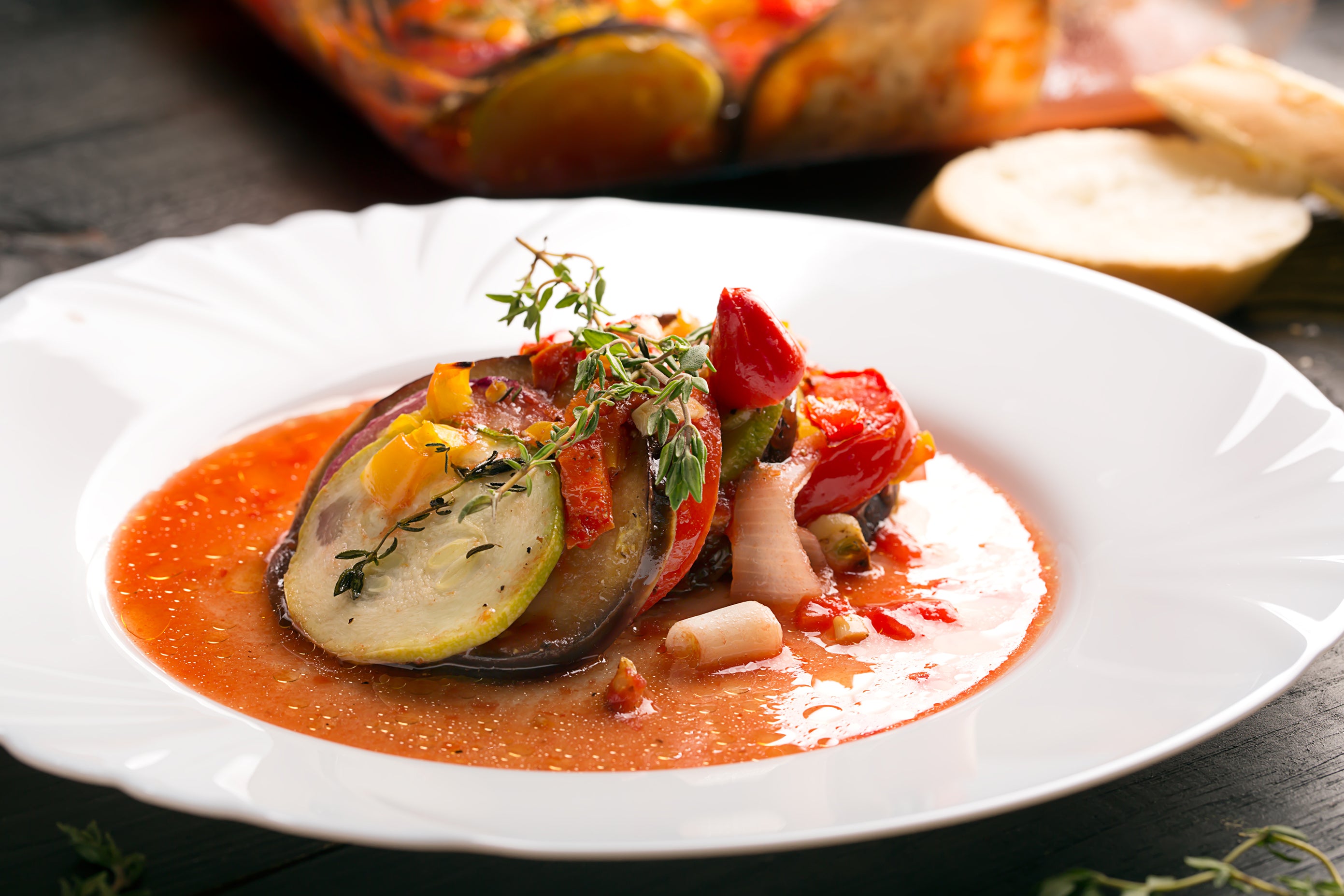 French Ratatouille is a vegetable stew made with eggplant, tomatoes, peppers, and fennel, flavored with herbs such as thyme and rosemary.