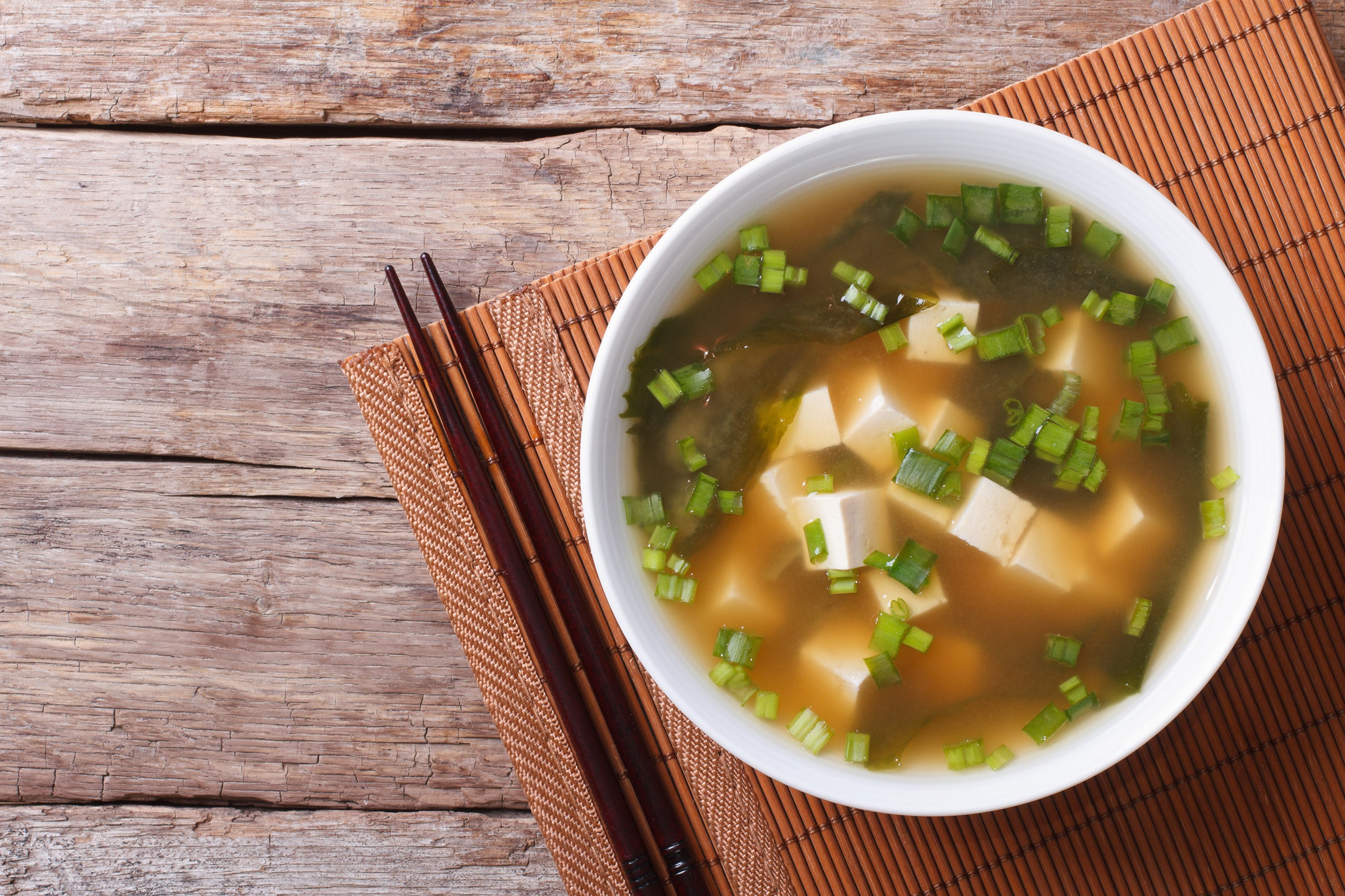 Japanese Miso Soup is made with miso paste, tofu, and seaweed, flavored with ginger and green onions.