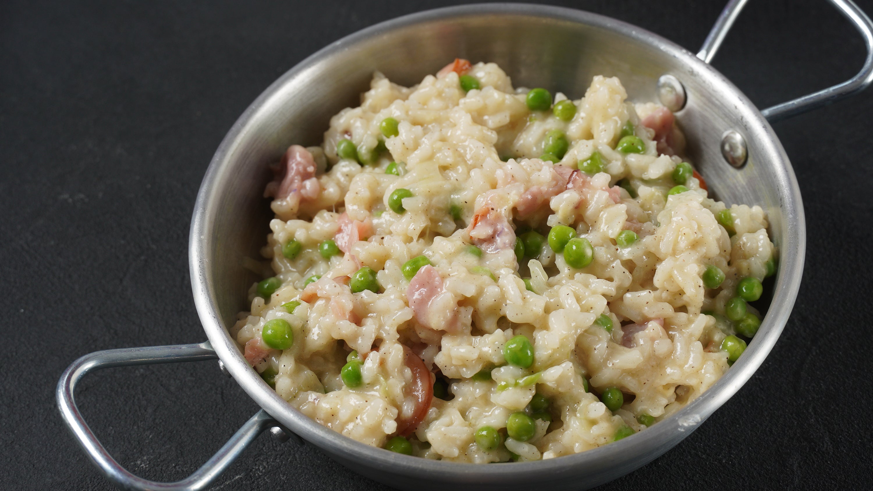 Risotto with Peas and Prosciutto is a creamy and flavorful rice dish made with Arborio rice, peas, prosciutto, and Parmesan cheese.